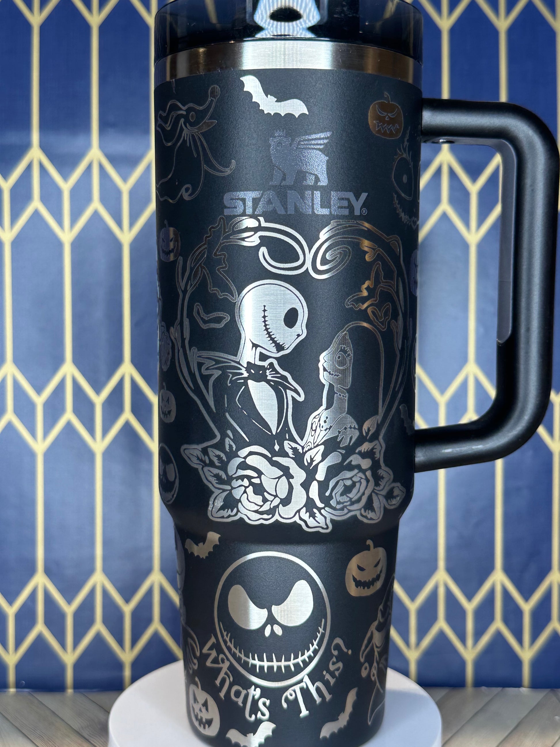 a black coffee cup with skulls and roses on it