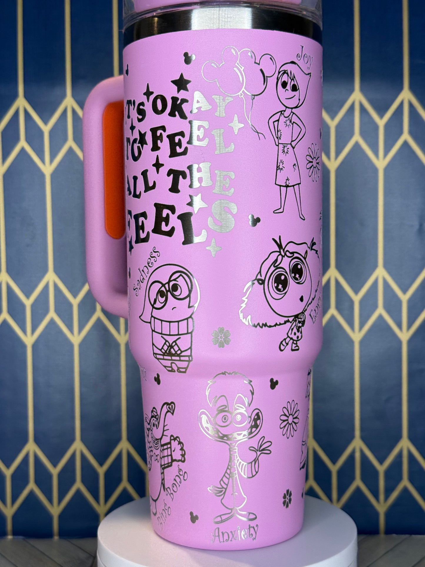 a pink cup that has drawings on it