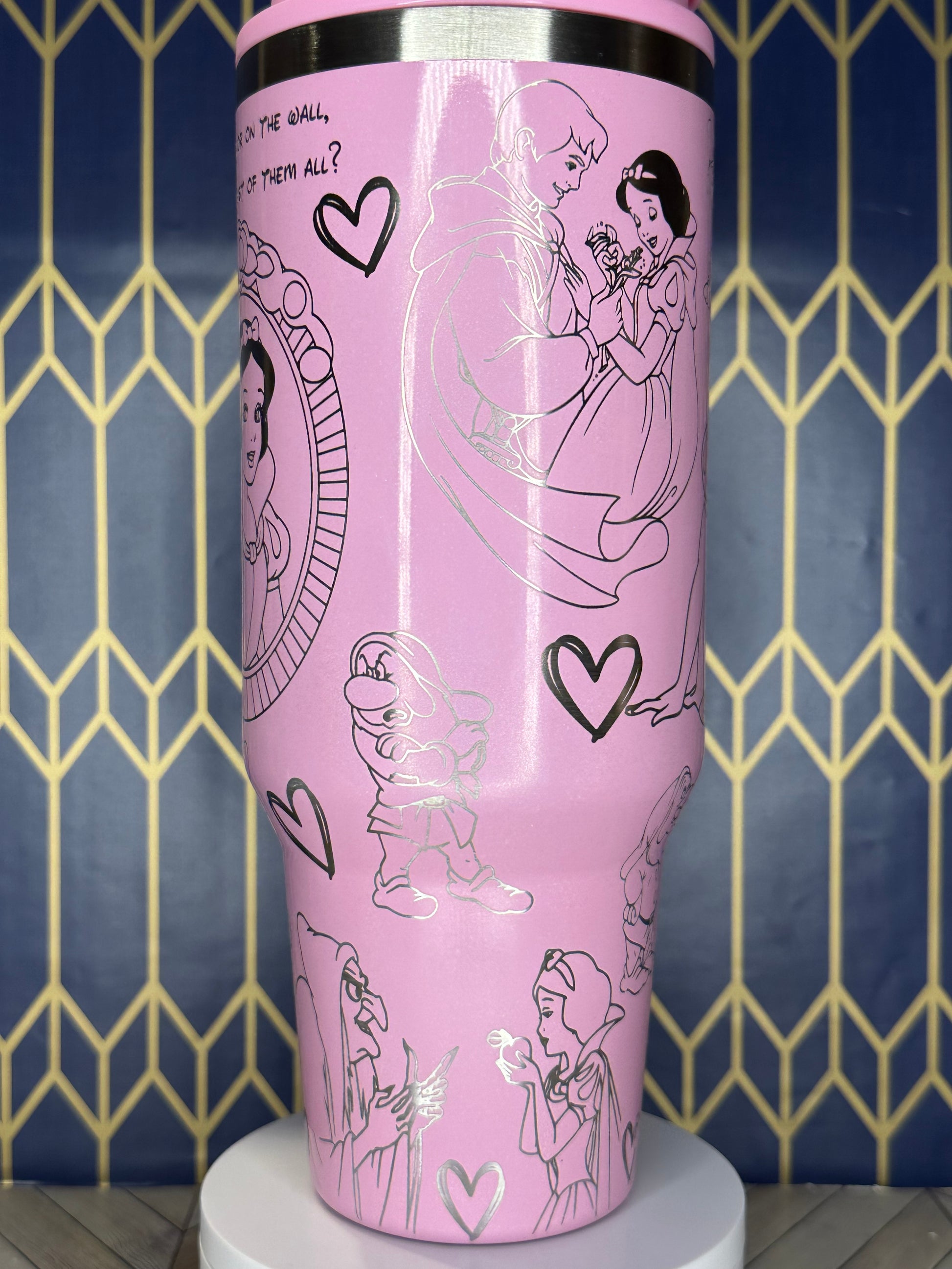 a close up of a pink cup with drawings on it