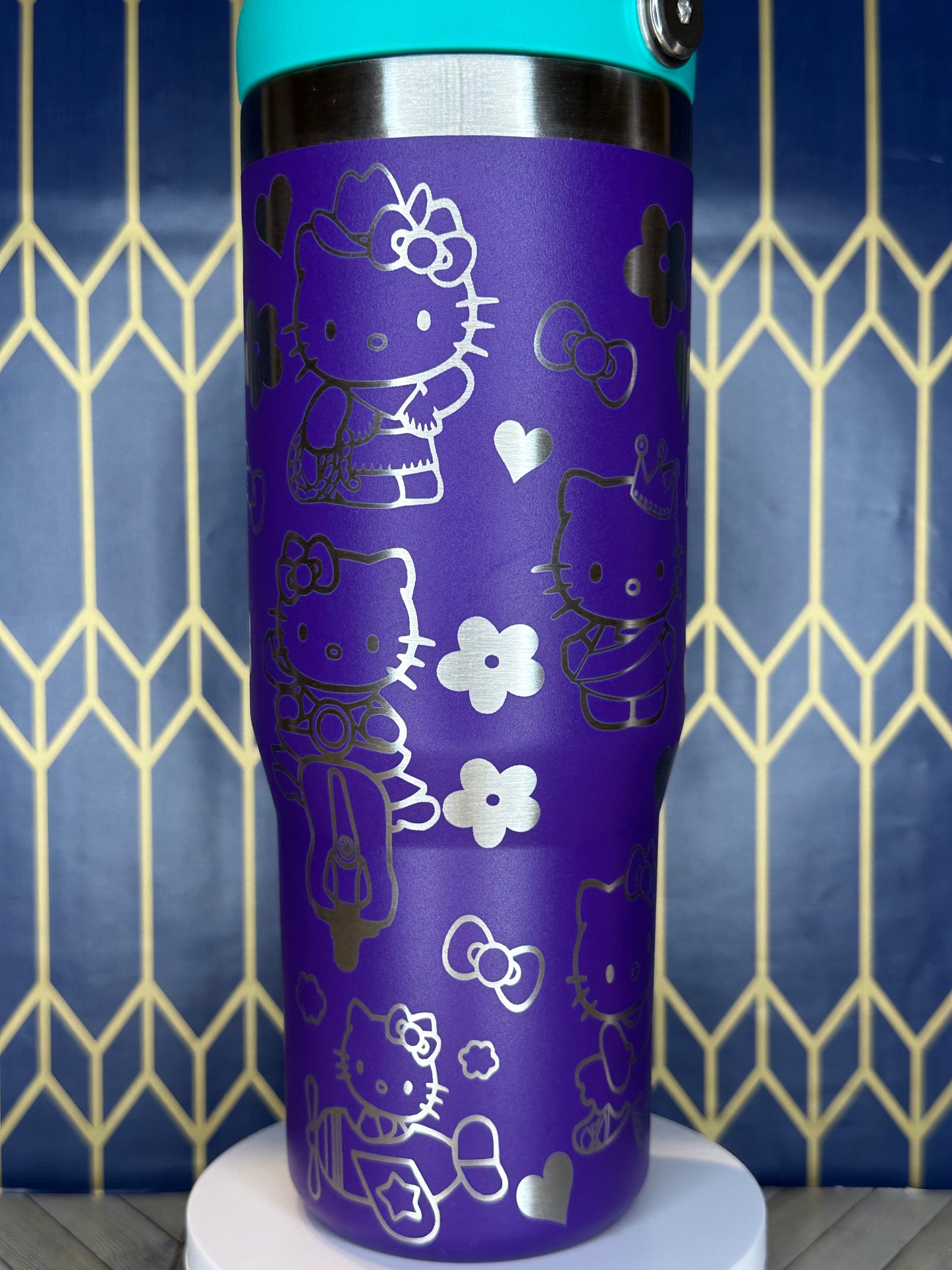 a purple and blue cup with hello kitty designs on it