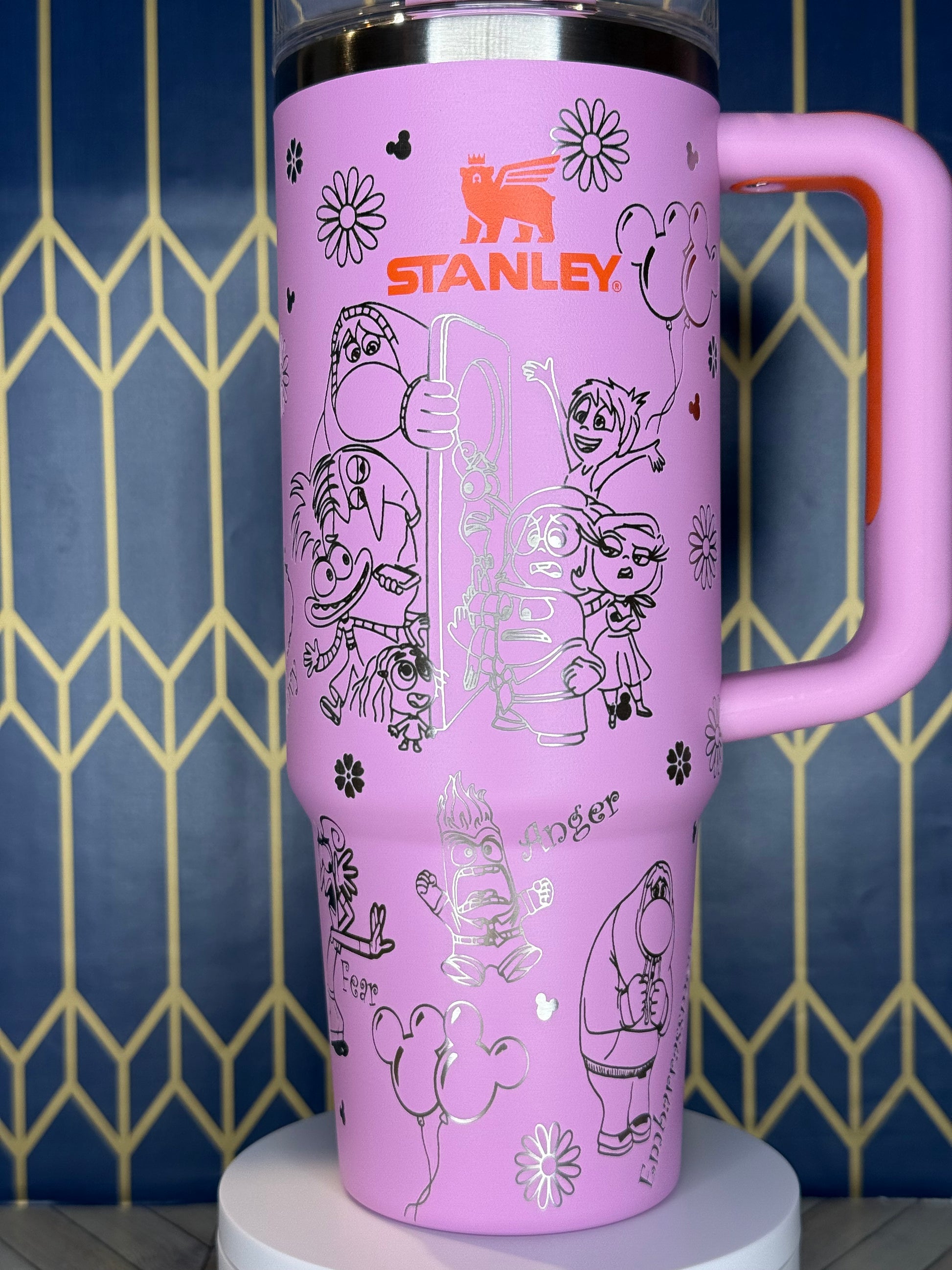 a pink water bottle with mickey mouse drawings on it