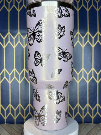 a close up of a cup with butterflies on it